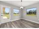 Dining area with wood-look floors, a glass door, and natural light from two windows at 6273 Toronja Dr, Indian Lake Estates, FL 33855