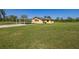 Single Gathering home featuring a large lawn, an attached carport, and dark shutters at 6273 Toronja Dr, Indian Lake Estates, FL 33855