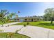 Charming single-story home with a well-manicured lawn, attached garage, carport, and a welcoming driveway at 6273 Toronja Dr, Indian Lake Estates, FL 33855