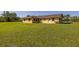 Inviting single-story home with a well-maintained, expansive green lawn in a serene, sunny setting at 6273 Toronja Dr, Indian Lake Estates, FL 33855