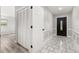 Hallway with tile and wood floors, fresh paint and white doors creates a bright and clean interior at 6273 Toronja Dr, Indian Lake Estates, FL 33855