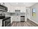 Bright kitchen with stainless steel appliances, white cabinets, and a stylish tile backsplash at 6273 Toronja Dr, Indian Lake Estates, FL 33855
