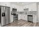 Modern kitchen featuring stainless steel appliances, subway tile backsplash, and white cabinetry at 6273 Toronja Dr, Indian Lake Estates, FL 33855