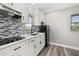 A modern kitchen featuring a tile backsplash, sleek countertops, and stainless-steel appliances at 6273 Toronja Dr, Indian Lake Estates, FL 33855