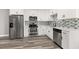 Modern kitchen features stainless steel appliances, sleek cabinets, and mosaic backsplash at 6273 Toronja Dr, Indian Lake Estates, FL 33855