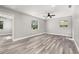 Spacious living room with gray walls, wood-look floors, and natural light from the windows at 6273 Toronja Dr, Indian Lake Estates, FL 33855