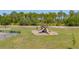 Community playground featuring slides and swings in a grassy area, offering a fun and safe space for children at 6273 Toronja Dr, Indian Lake Estates, FL 33855