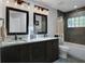 Modern bathroom features dual sinks, dark wood cabinets, and stunning stone tile at 700 Bear Shadow Ct, Longwood, FL 32779