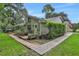 Backyard view showcasing a brick patio area, lush greenery, and the home's architecture at 700 Bear Shadow Ct, Longwood, FL 32779