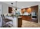 Updated kitchen with wooden cabinets, granite countertops, and a breakfast bar for casual dining at 700 Bear Shadow Ct, Longwood, FL 32779
