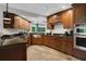Modern kitchen with stainless steel appliances, granite countertops, and wood cabinets, designed for functionality at 700 Bear Shadow Ct, Longwood, FL 32779