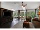 Cozy living room featuring dark hardwood floors, plush seating, and a view of lush landscaping at 700 Bear Shadow Ct, Longwood, FL 32779