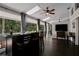 Spacious living room featuring dark hardwood floors, a bar area, and multiple windows providing picturesque views at 700 Bear Shadow Ct, Longwood, FL 32779