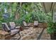 Outdoor patio area with comfortable seating, brick paving, and a private, tree-lined backdrop at 700 Bear Shadow Ct, Longwood, FL 32779