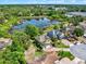 Aerial view showcasing a homesite nestled near a pond, surrounded by nature and other residences at 732 Wildmere Village Cv, Longwood, FL 32750