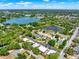 An aerial view showcases the community with homes and nearby ponds surrounded by trees at 732 Wildmere Village Cv, Longwood, FL 32750