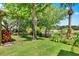 Lush backyard featuring mature trees, a pond view, and a charming seating area on a wooden dock at 732 Wildmere Village Cv, Longwood, FL 32750