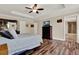 Bright bedroom with ensuite bath featuring wood-look flooring, tray ceiling, and ceiling fan at 732 Wildmere Village Cv, Longwood, FL 32750