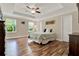 Relaxing bedroom features a tray ceiling, a ceiling fan, and beautiful wood-look flooring at 732 Wildmere Village Cv, Longwood, FL 32750