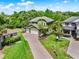 An overhead angled elevation shows the house with lush lawn, two-car garage and brick driveway at 732 Wildmere Village Cv, Longwood, FL 32750