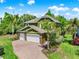 An elevated side angled elevation view of the home shows the two-car garage and brick driveway at 732 Wildmere Village Cv, Longwood, FL 32750