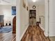 Inviting hallway with hardwood floors leading to an office space; featuring a classic bookshelf and decor at 732 Wildmere Village Cv, Longwood, FL 32750