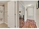 Bright hallway with an open doorway leading to the bedroom with wood-look flooring at 732 Wildmere Village Cv, Longwood, FL 32750