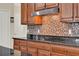 Detailed view of kitchen with granite countertops and a stylish mosaic tile backsplash at 732 Wildmere Village Cv, Longwood, FL 32750