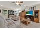 Inviting living room with tile flooring, ceiling fan, and a cozy fireplace under a wall-mounted television at 732 Wildmere Village Cv, Longwood, FL 32750