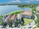 Stunning aerial view of waterfront homes on a picturesque lake surrounded by lush greenery and clear blue skies at 7613 Toscana Blvd, Orlando, FL 32819