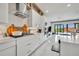 Bright, all-white kitchen featuring quartz countertops, modern appliances, and sliding glass doors to the outdoor area at 7613 Toscana Blvd, Orlando, FL 32819