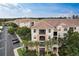 Aerial view showcasing the building's tile roof, exterior details, landscaping and convenient parking at 8296 Portofino Dr # 103, Davenport, FL 33896