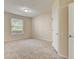 Bedroom features neutral carpet, white trim, and a large window at 8296 Portofino Dr # 103, Davenport, FL 33896