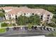 Condo building with tile roof and parking lot, with trees and landscaping at 8296 Portofino Dr # 103, Davenport, FL 33896