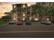 Exterior view of a condo building with palm trees in a parking area at dusk at 8296 Portofino Dr # 103, Davenport, FL 33896