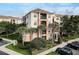 Condo building with balconies, well maintained landscaping, and manicured lawn at 8296 Portofino Dr # 103, Davenport, FL 33896