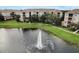 Condo building overlooking a pond with a fountain and grassy lawns at 8296 Portofino Dr # 103, Davenport, FL 33896