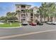 Condo building with balconies, well maintained landscaping, and parking lot at 8296 Portofino Dr # 103, Davenport, FL 33896