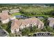 Aerial shot of condo building with tile roof overlooking a pond and parking lot at 8296 Portofino Dr # 103, Davenport, FL 33896