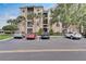 Exterior view of a three-story condo building with palm trees and parking at 8296 Portofino Dr # 103, Davenport, FL 33896