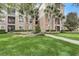 Manicured condo exterior with palm trees, lawn, landscaping, and sidewalk at 8296 Portofino Dr # 103, Davenport, FL 33896