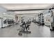 A modern gym equipped with weight machines, free weights, and treadmills overlooks outdoor scenery at 8296 Portofino Dr # 103, Davenport, FL 33896