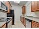 Bright kitchen featuring stainless steel appliances, granite counters, and wood cabinets at 8296 Portofino Dr # 103, Davenport, FL 33896