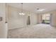 Spacious living room with neutral carpet and access to a sliding glass door at 8296 Portofino Dr # 103, Davenport, FL 33896