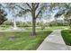 Scenic pond with fountain, mature tree, and walking path at 8296 Portofino Dr # 103, Davenport, FL 33896