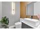 Modern powder room featuring a vessel sink, wood paneling, and stylish light fixture at 8972 Sonoma Coast Dr, Winter Garden, FL 34787
