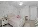 A whimsical bedroom with polka dot wallpaper, plush toys, and a decorative chandelier at 8972 Sonoma Coast Dr, Winter Garden, FL 34787