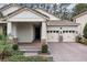 Close-up view of the home's entrance, revealing its covered porch, two-car garage, and meticulous landscaping at 8972 Sonoma Coast Dr, Winter Garden, FL 34787