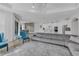 Open-concept living room with a large gray sofa, kitchen with stainless steel appliances, and a dining area at 8972 Sonoma Coast Dr, Winter Garden, FL 34787