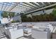 Inviting outdoor lounge area with white wicker furniture and a shaded pergola for relaxing at 8972 Sonoma Coast Dr, Winter Garden, FL 34787